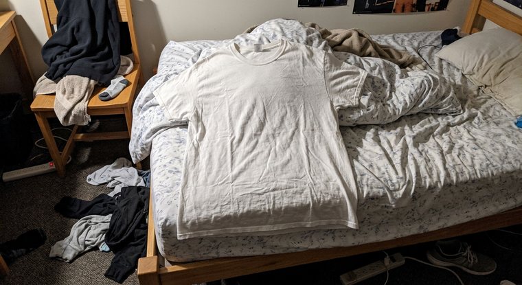 Foto kaos putih biasa hasil foto hp di atas sprei yang berkerut